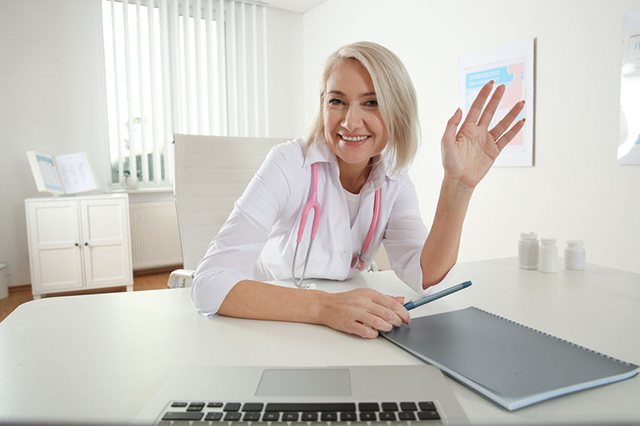 Lady doctor smiling and waving